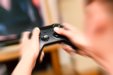 Obraz na płótnie Canvas Close-up blur hands with movement pressing and holding a modern game console joystick