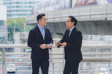 two attractive business man using touching pad on smartphone and tablet technology connecting social online with discussion about business strategy growing.