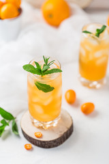 Fresh summer cocktail with orange juice and ice cubes. Glass of orange soda drink on white background