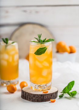 Fresh summer cocktail with orange juice and ice cubes. Glass of orange soda drink on white background