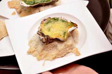 Oysters with sauce Sabayon. Oysters baked on a pillow of salt, with cheese.