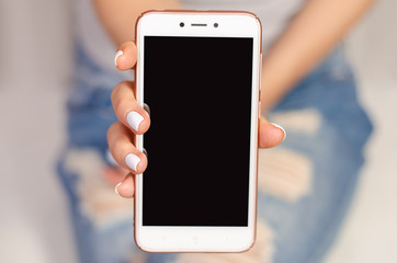 Woman in jeans looks at mobile phone smartphone touch device fashion beauty