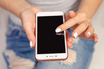 Woman in jeans looks at mobile phone smartphone touch device fashion beauty