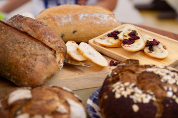 Various kind of delicious breads are arranged on brown wood background with copy space.