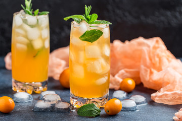Fresh summer cocktail with orange juice and ice cubes. Glass of orange soda drink on dark background
