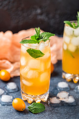 Fresh summer cocktail with orange juice and ice cubes. Glass of orange soda drink on dark background