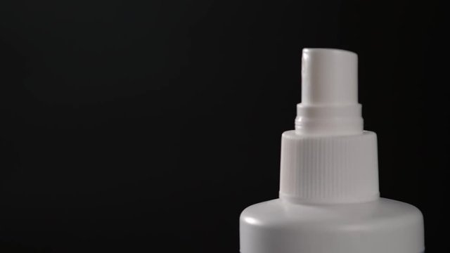 Close-up view of human hand and spray bottle isolated on black parfume moscito spray insects