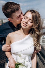 The bride and groom embracing and standing on the ballcony