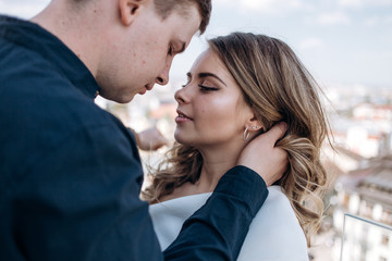 Fototapeta premium The bride and groom embracing and standing on the ballcony