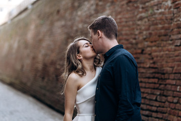 The lovely couple in love standing and kissing on the street
