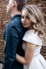 Fototapeta premium The lovely couple in love embracing and standing on the street