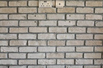 gray brick wall with electrical outlet