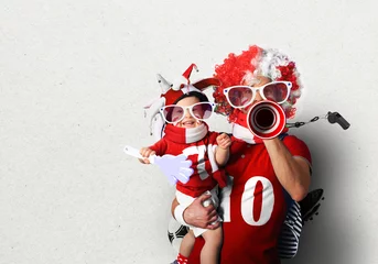 Tuinposter Football fans, father in a wig and the son © Zarya Maxim