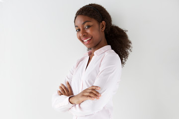attractive young african american woman smiling with arms crossed on white background
