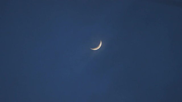 In a summer night here a crescent moon in blue sky. This clip was shot with a Canon C300
