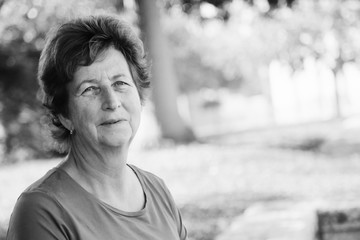 close up portrait of senior woman walking on the summer green park