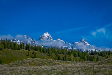 Grand Tetons range in morning light, with a huge mounatins partial covered with snow in the...