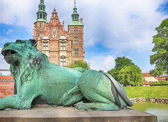 Copenhagen - beautiful view of Rosenborg castle from the King's garden with a bronze lion at the entrance gate. The castle was built as country summerhouse in 1606 in Dutch Renaissance style. 