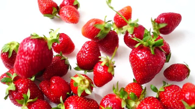 Falling of berries of strawberry on a white background. Slow motion.