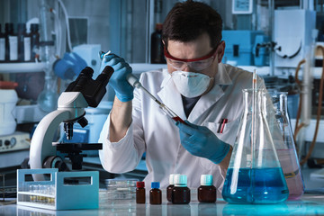 scientist pipetting sample of tube test in the research laboratory / researcher holding pipette and...