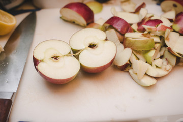 Apples cut up on a cutting board with a knife by them.