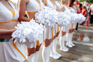 Cheerleaders in white Uniform Holding Pom-Poms. Close up . football championship
