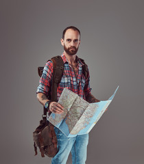 Portrait of a handsome tattooed traveler in a flannel shirt with