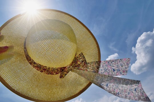 Straw hat, blue sky and sunlight - summer holiday concept, freedom, happiness, traveling