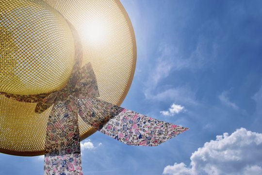 Straw hat, blue sky and sunlight - summer holiday concept, freedom, happiness, traveling
