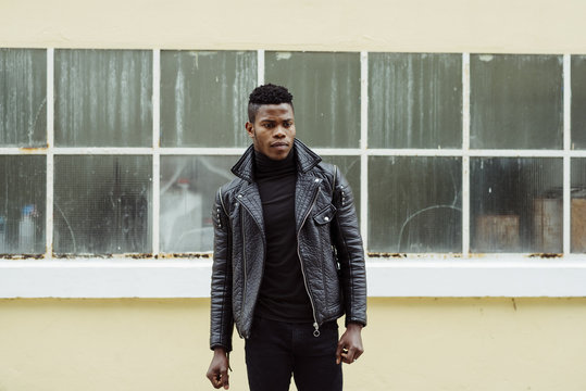 African man posing outdoors close to windows