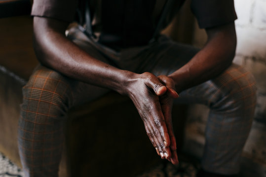 Black man folding hands together