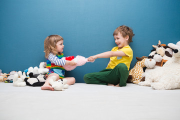 Two little kids, brother and sister fighting over a toy. the conflict between children..