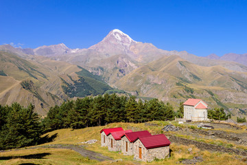 Orthodox Church on Kazbek mountain background, beautiful summer view, Kazbegi (Stepantsminda) village, Georgia