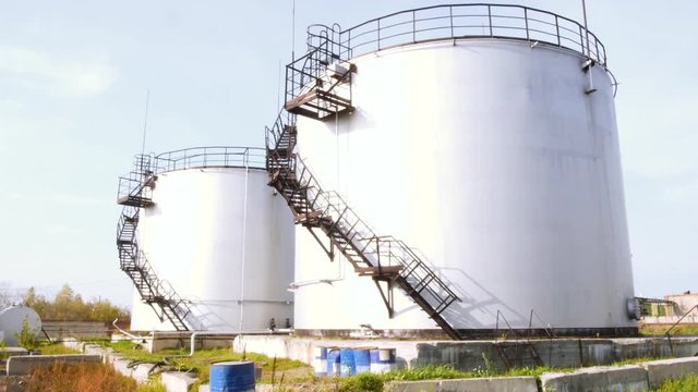Large white Industrial tanks for petrol and oil. Stock. Fuel tanks at the tank farm. Big Industrial oil tanks in a refinery