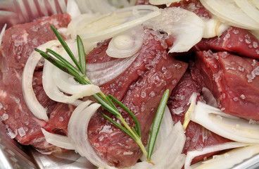 Marinating meat. Semifinished. Marinated pieces of meat with onion, rosemary and sea salt.