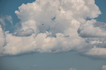 Little plane approaching into the blue Germany sky with white clouds