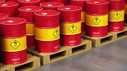 Group of rows of red stacked oil drums in storage warehouse