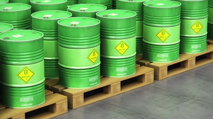 Group of rows of green stacked biofuel drums in storage warehouse