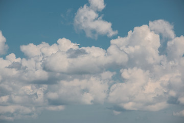 Little plane approaching into the blue Germany sky with white clouds