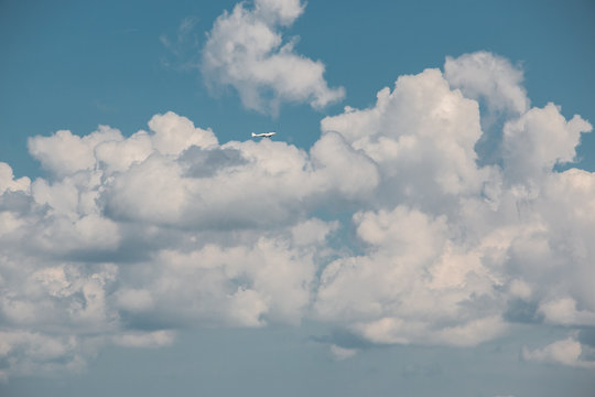 Little plane approaching into the blue Germany sky with white clouds