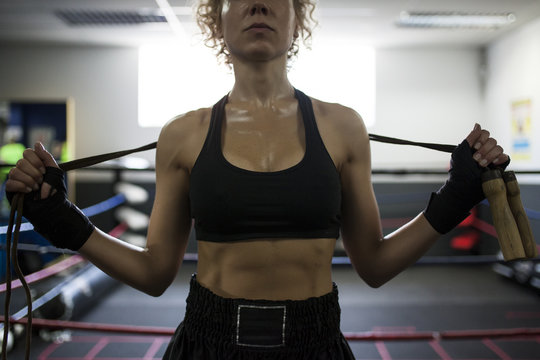 Muscular woman holding wooden jump rope