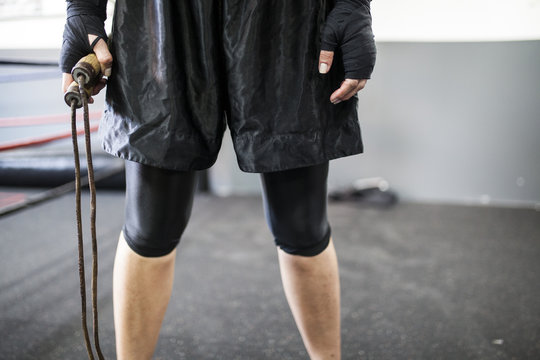 Muscular woman holding wooden jump rope