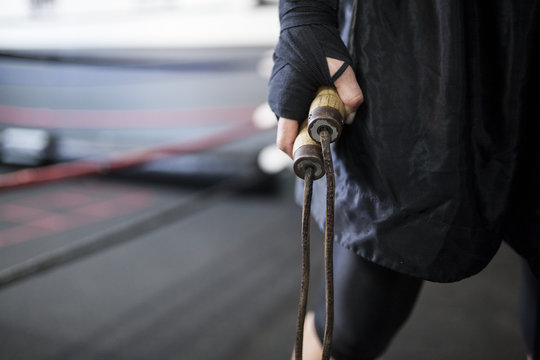Muscular woman holding wooden jump rope
