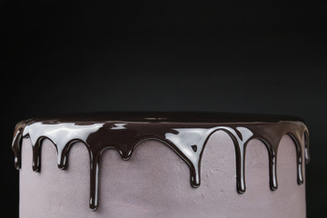 Chocolate cake with black glaze on a black background. Picture for a menu or a confectionery catalog.