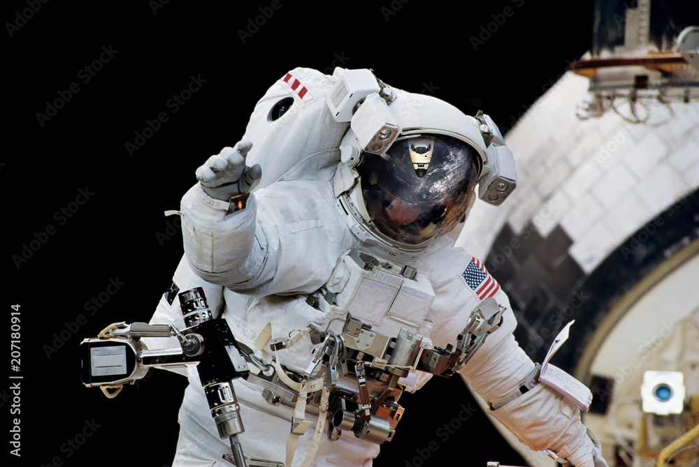 Wall mural close up of an astronaut waving hi to the camera.elements of this image furnished by nasa.