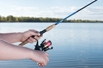 Fishing on a summer day. Closeup of male hands with spinning