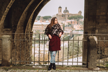 Fototapeta premium Young girl leaning against the wall. she was dressed in autumn clothes. she is beautiful and cheerful