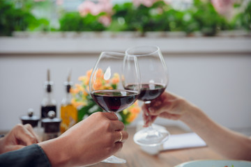 Beautiful young couple with glasses of red wine in luxury restaurant