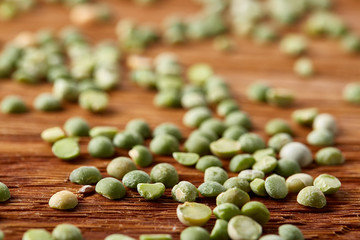Green peas on rustic wooden background, close-up, top view, selective focus, shallow depth of field.