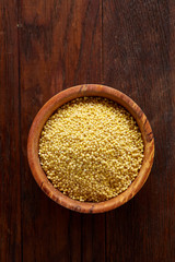 Lentils in a wooden bowl on rustic wooden background, top view, close-up, selective focus.